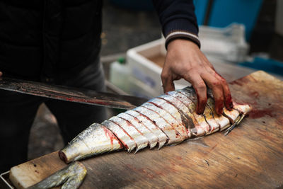 Midsection of man preparing fish