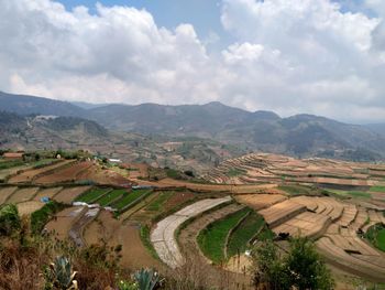 High angle view of agricultural field against sky with foggy environment .