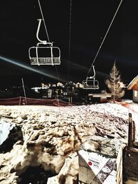Snow covered land against sky at night