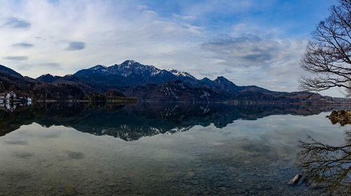 Scenic view of lake by mountains against sky