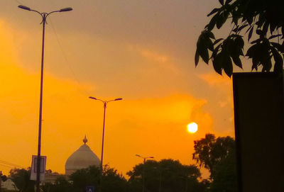 Silhouette trees and buildings against sky during sunset