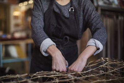 Midsection of female worker making chaise longue at workshop