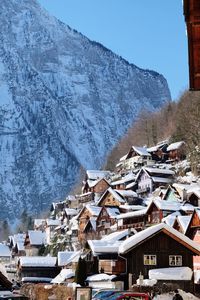 Houses by snow covered mountain against sky