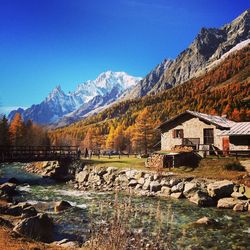 Buildings by mountain against blue sky