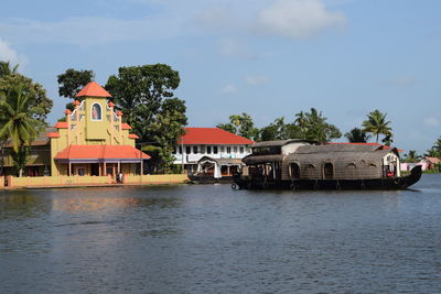 Houses by river against sky