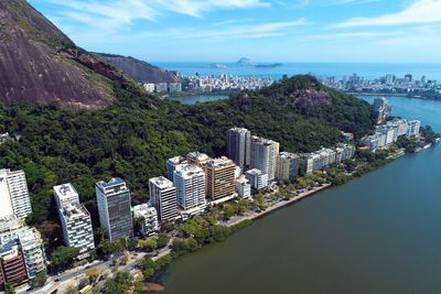 High angle view of buildings by sea against sky