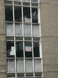 Low angle view of text on glass window of building