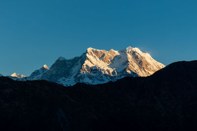 Scenic view of snowcapped mountains against clear blue sky