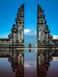 Reflection of historic building against blue sky