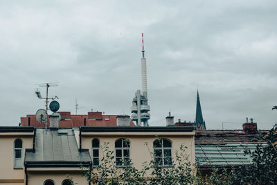 Buildings in city against cloudy sky