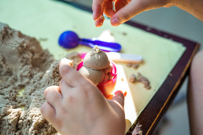 Close-up of person using sand