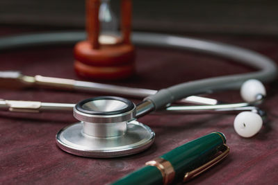 Close-up of stethoscope and pen on table