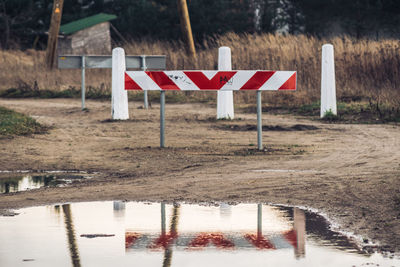 Road sign on puddle by lake