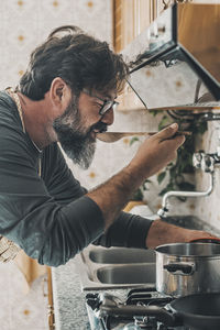 Side view of man preparing food in kitchen