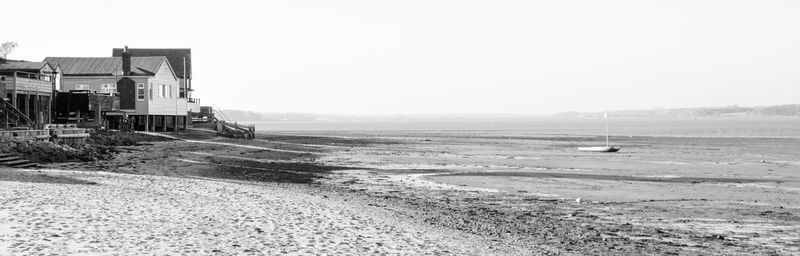 Panoramic view of abandoned building on field against clear sky