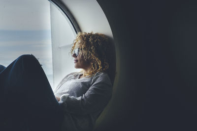 Rear view of woman looking through window