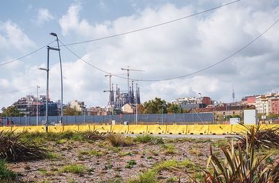 Electricity pylon in city against sky