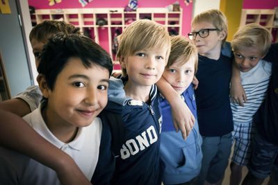 Portrait of happy boys standing in school corridor