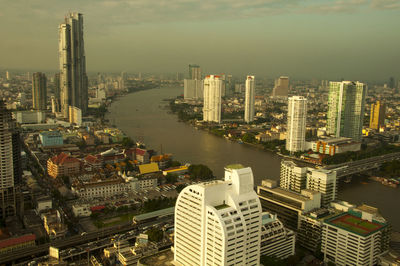 High angle view of river amidst buildings in city against sky