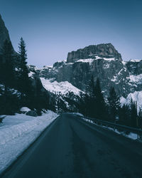 Road amidst snow covered mountain against sky