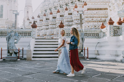 Woman standing outside temple against building