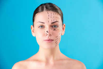 Portrait of young woman against blue background