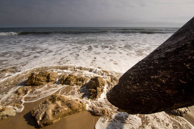 Close-up of rocks on beach against sky