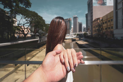 Midsection of woman hand on railing in city