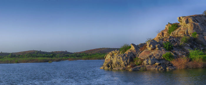 Rock formations by sea against sky