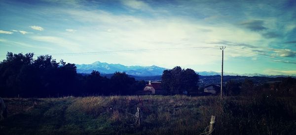 Scenic view of field against cloudy sky