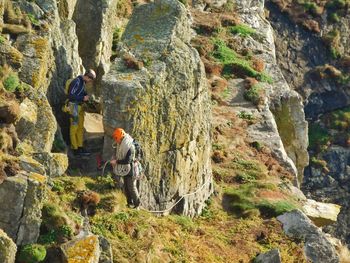 People standing on rock by mountain