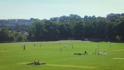 People relaxing on grassy field