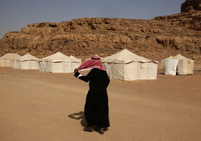 Rear view of man walking at desert