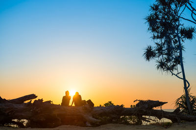 Scenic view of rocks against clear sky during sunset