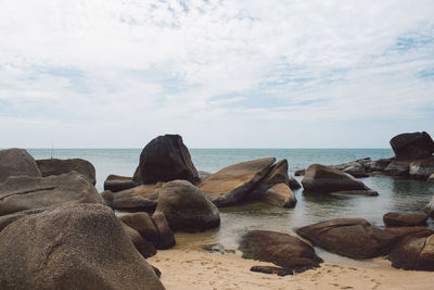 Rocks on beach against sky