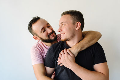 Two gay men kissing in white background