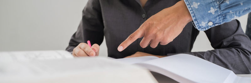 Midsection of man and woman reading book