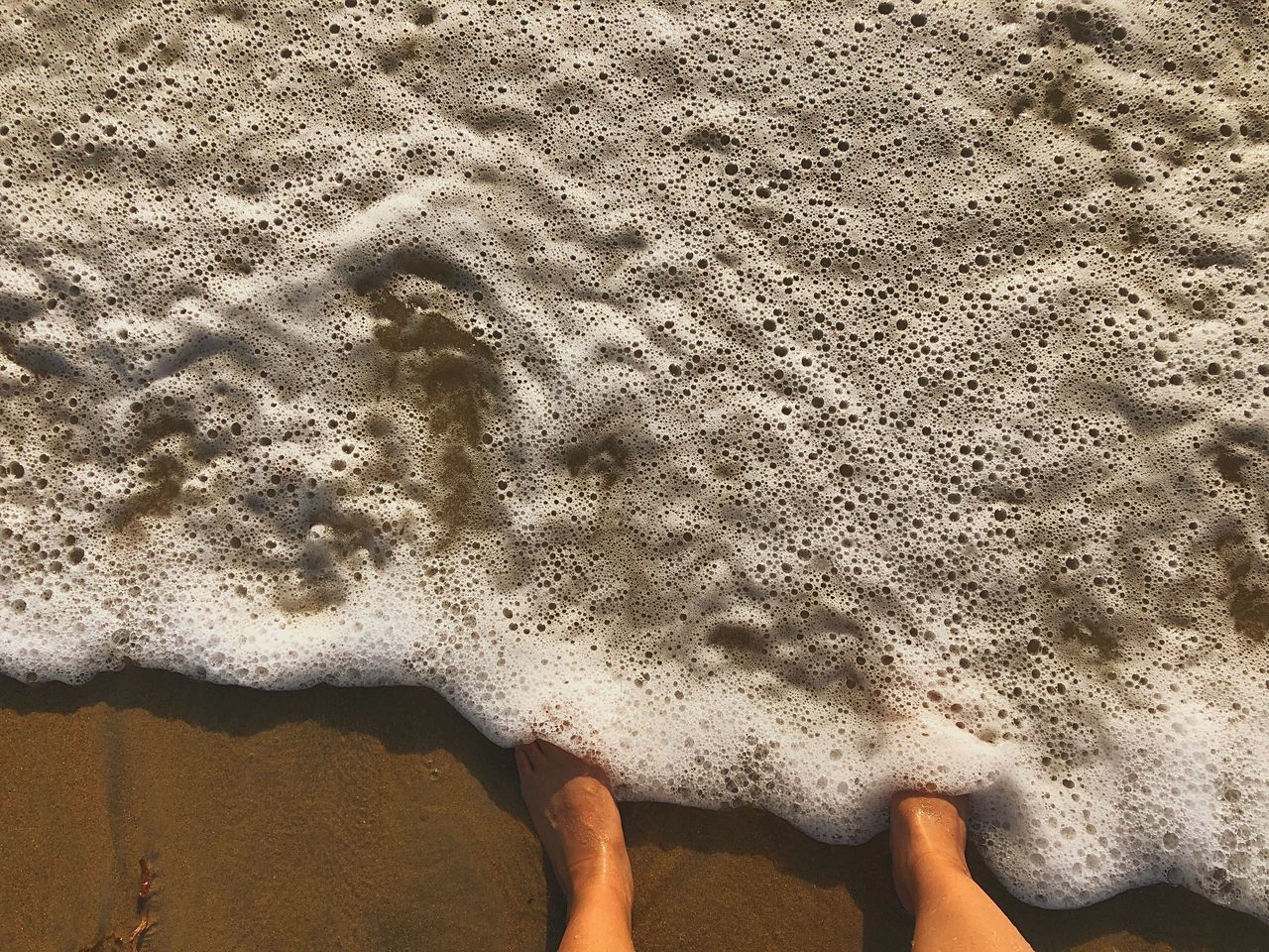 sand, real people, land, beach, low section, human body part, lifestyles, leisure activity, one person, body part, nature, sea, personal perspective, high angle view, water, human leg, barefoot, standing, hand, outdoors, human foot