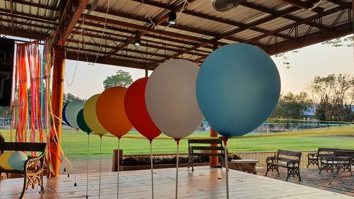 Multi colored balloons at park against sky