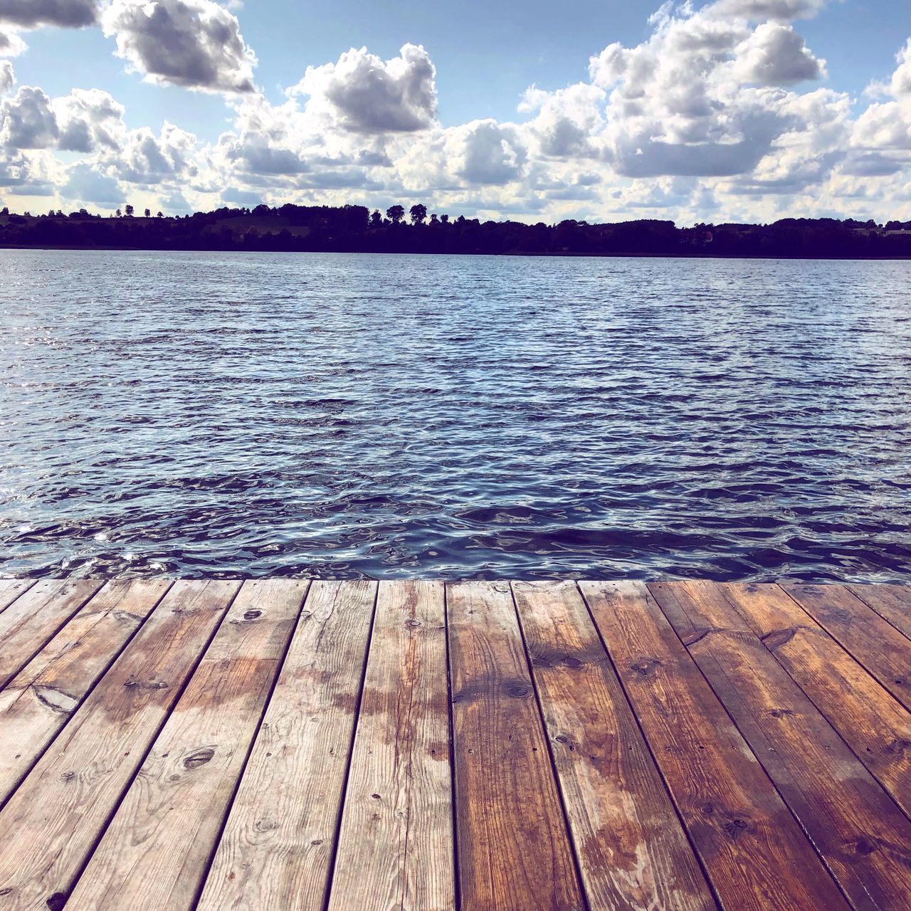 WOODEN PIER ON LAKE AGAINST SKY