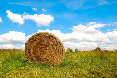 Hay bales on field against sky