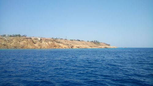 Scenic view of sea against clear blue sky