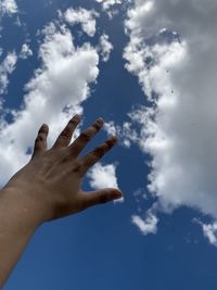 Low angle view of hand against sky