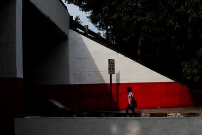 Full length of man standing by wall