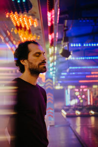 Young man looking at illuminated city at night