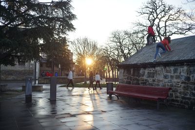 People at observation point against sky during sunset