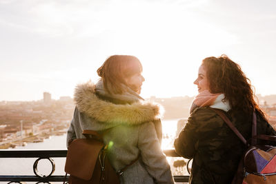 Two happy friends porto bridge sightseeing at sunset. travel, friendship and lifestyle