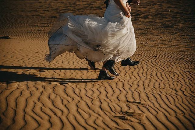 animal themes, low section, bird, sunlight, sand, walking, lifestyles, shadow, men, high angle view, standing, outdoors, day, full length, leisure activity, pattern, person