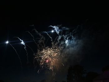 Low angle view of fireworks against sky at night