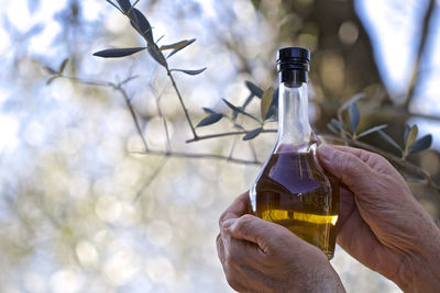 Close-up of hand holding glass bottle